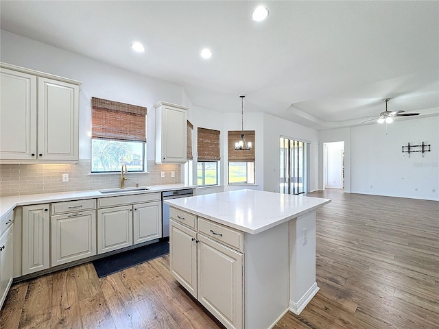 kitchen featuring sink, hardwood / wood-style flooring, dishwasher, hanging light fixtures, and a center island