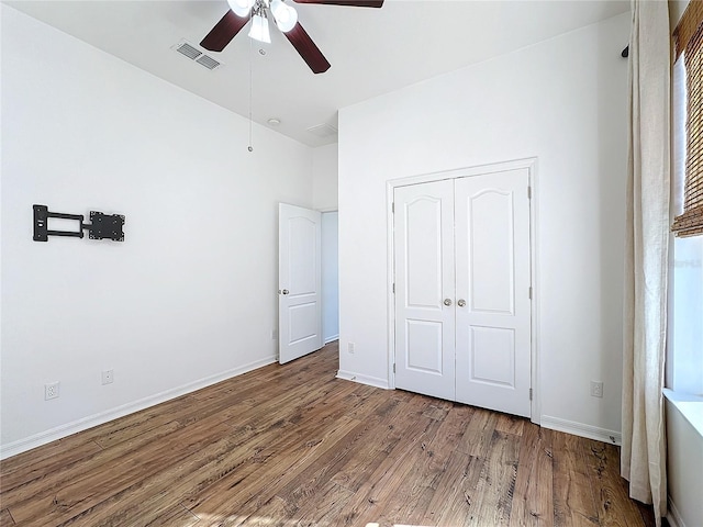 unfurnished bedroom featuring wood-type flooring, a closet, and ceiling fan