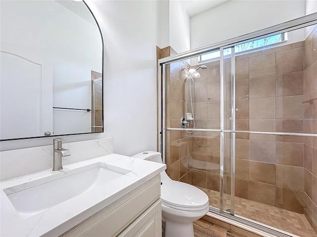 bathroom featuring vanity, an enclosed shower, and toilet