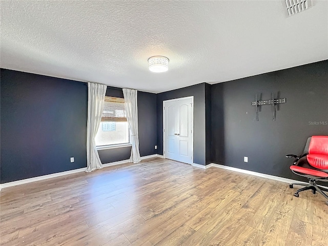 interior space featuring a textured ceiling and light wood-type flooring