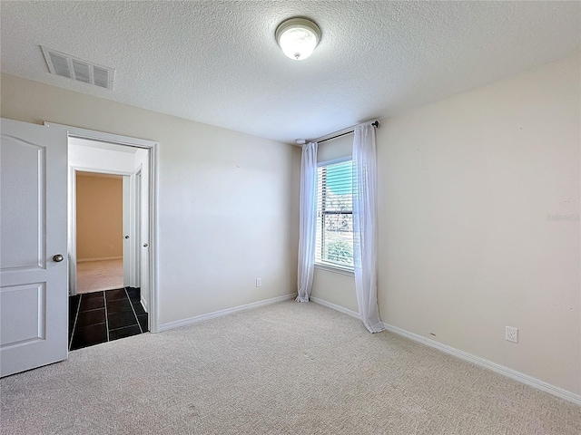 empty room featuring carpet floors and a textured ceiling