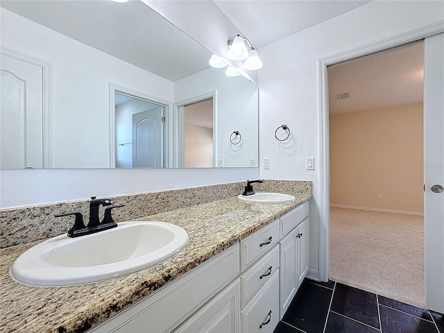 bathroom featuring tile patterned floors, vanity, and a textured ceiling