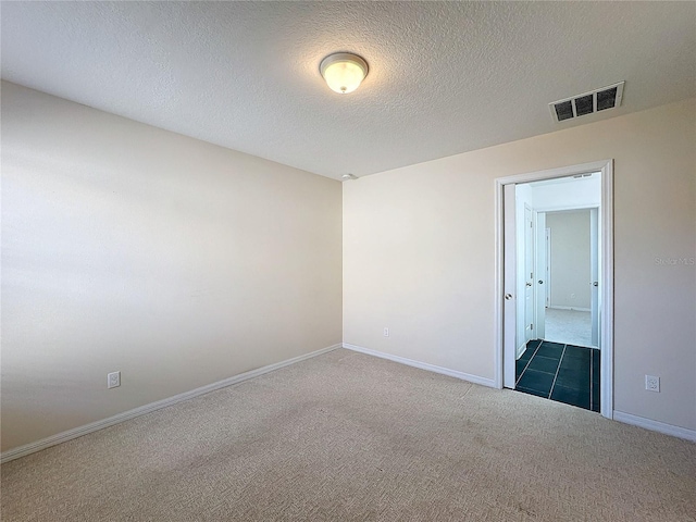 spare room with carpet flooring and a textured ceiling