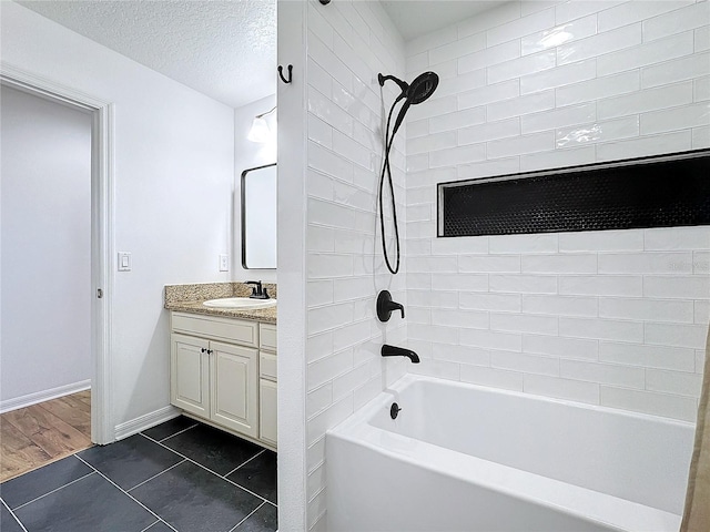 bathroom featuring tiled shower / bath combo, vanity, tile patterned flooring, and a textured ceiling