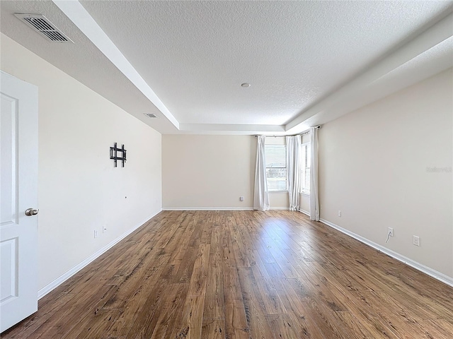 empty room featuring wood-type flooring and a textured ceiling