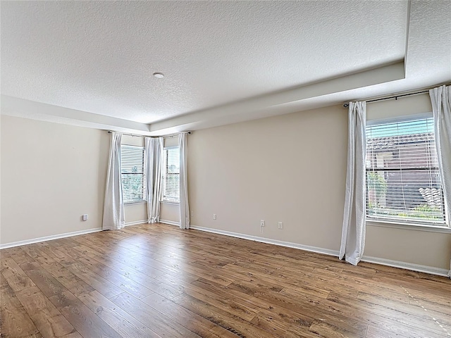 spare room featuring wood-type flooring and a textured ceiling