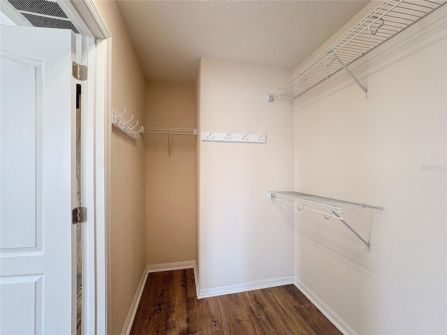 walk in closet featuring dark wood-type flooring