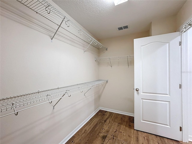 walk in closet featuring dark wood-type flooring