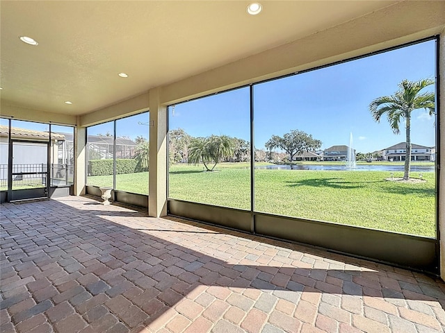 unfurnished sunroom featuring a water view