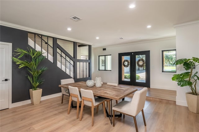 dining room featuring ornamental molding, french doors, and light wood-type flooring