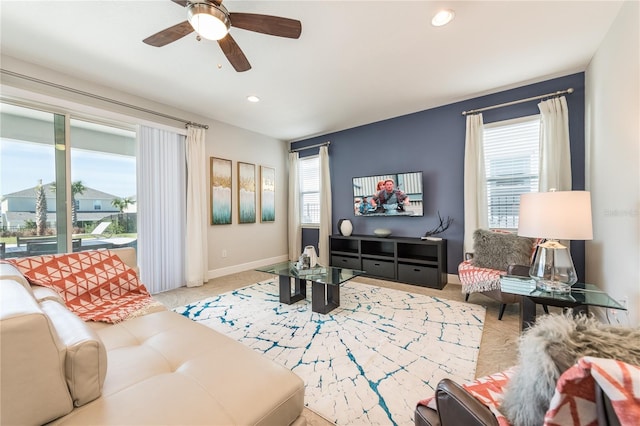 carpeted living room with ceiling fan