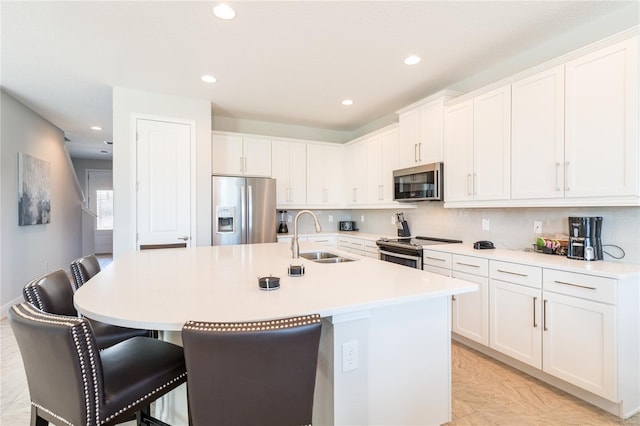 kitchen with stainless steel appliances, a kitchen breakfast bar, sink, and a center island with sink