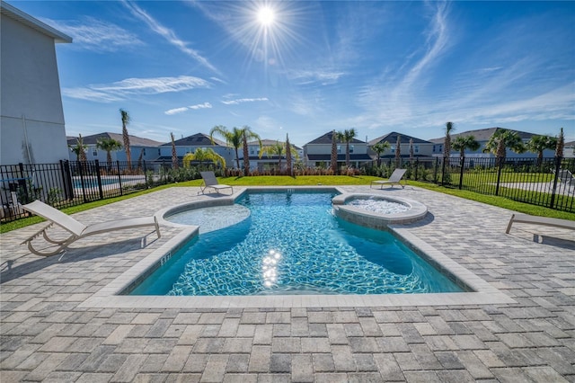 view of pool featuring an in ground hot tub, pool water feature, and a patio