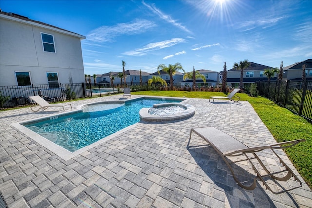 view of swimming pool with a patio area, a hot tub, and a lawn