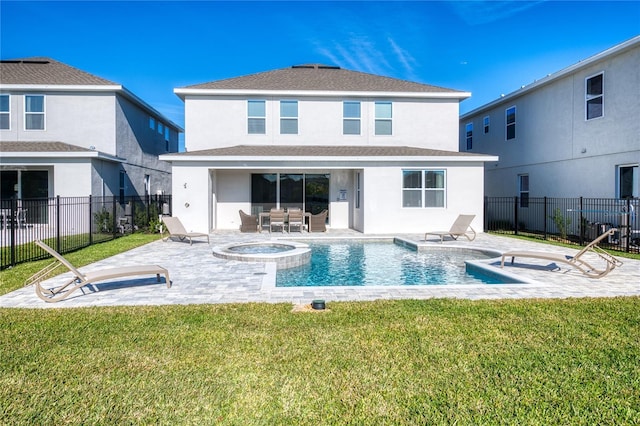 rear view of property with a pool with hot tub, a patio, and a lawn