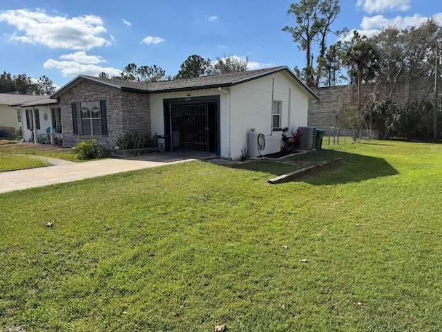 view of front facade featuring a garage, a front lawn, and central air condition unit