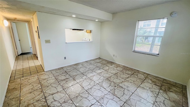 unfurnished room with a textured ceiling