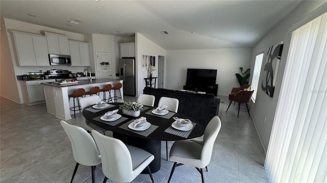 tiled dining area featuring lofted ceiling