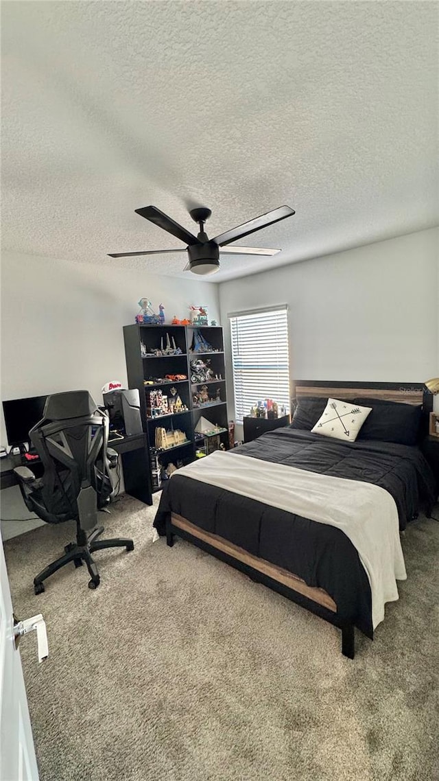 bedroom featuring carpet flooring, a textured ceiling, and ceiling fan