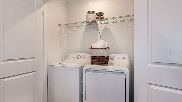 clothes washing area with separate washer and dryer