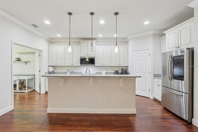 kitchen with stainless steel appliances, an island with sink, a breakfast bar, and white cabinets