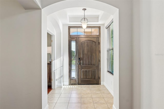 tiled entryway featuring a tray ceiling