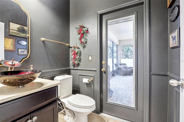 bathroom featuring vanity, tile patterned flooring, and toilet