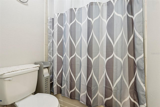 bathroom featuring curtained shower and toilet