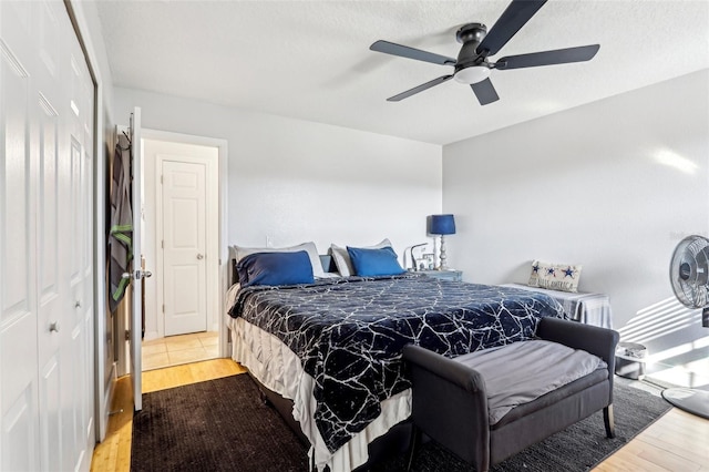 bedroom with light hardwood / wood-style flooring, a closet, and ceiling fan