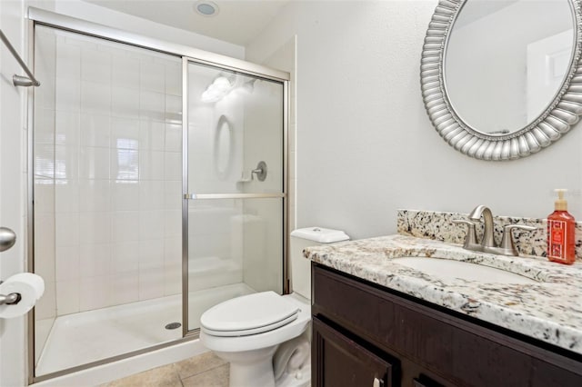 bathroom featuring vanity, toilet, tile patterned flooring, and a shower with door