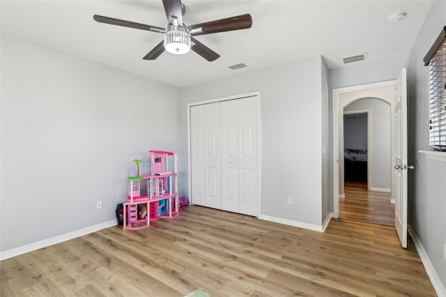 recreation room with ceiling fan and light wood-type flooring