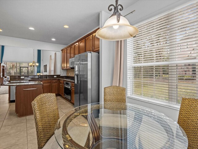 1431 Milledge Ln, Davenport, FL 33896 - kitchen with a chandelier, hanging light fixtures, a center island, light tile patterned floors, and stainless steel appliances