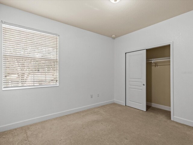 1431 Milledge Ln, Davenport, FL 33896 - unfurnished bedroom with light colored carpet and a closet