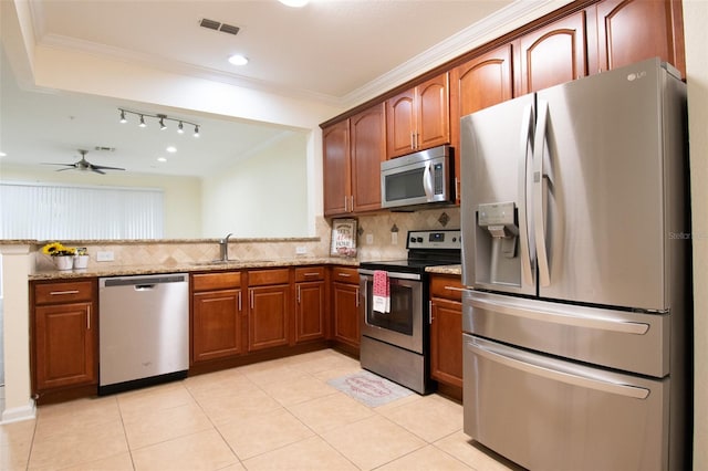 kitchen with appliances with stainless steel finishes, light stone countertops, decorative backsplash, ornamental molding, and sink