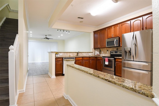 kitchen featuring light tile patterned floors, stainless steel appliances, light stone counters, and decorative backsplash