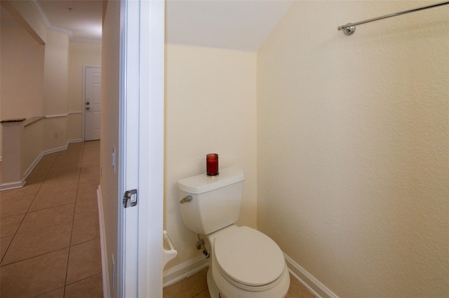 bathroom with toilet, tile patterned flooring, and crown molding