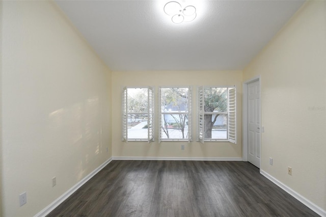 unfurnished room featuring vaulted ceiling and dark hardwood / wood-style flooring