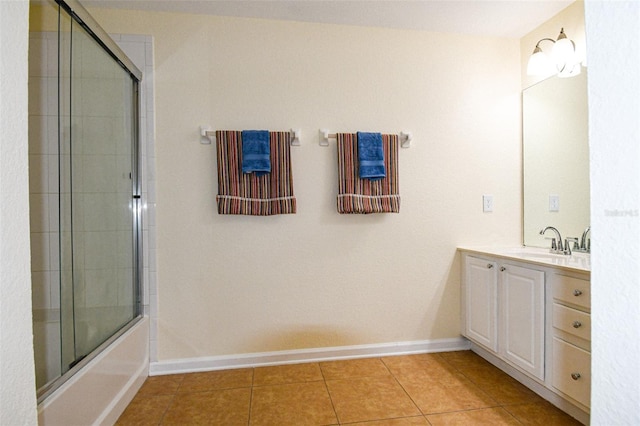 bathroom with tile patterned flooring, vanity, and combined bath / shower with glass door