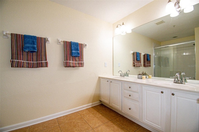 bathroom with vanity, a shower with door, and tile patterned floors
