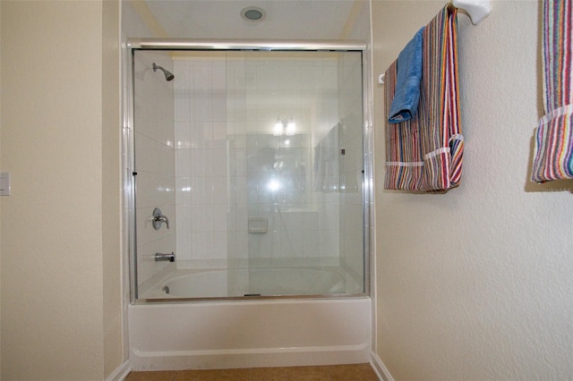bathroom with bath / shower combo with glass door