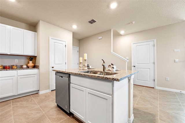 kitchen with sink, dishwasher, light stone counters, an island with sink, and white cabinets