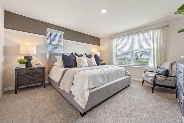 bedroom featuring light carpet and a textured ceiling