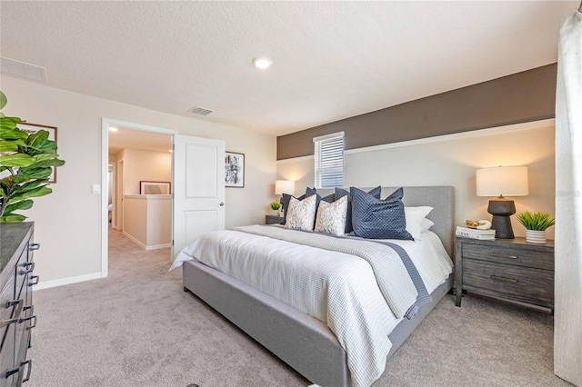 bedroom with light carpet and a textured ceiling