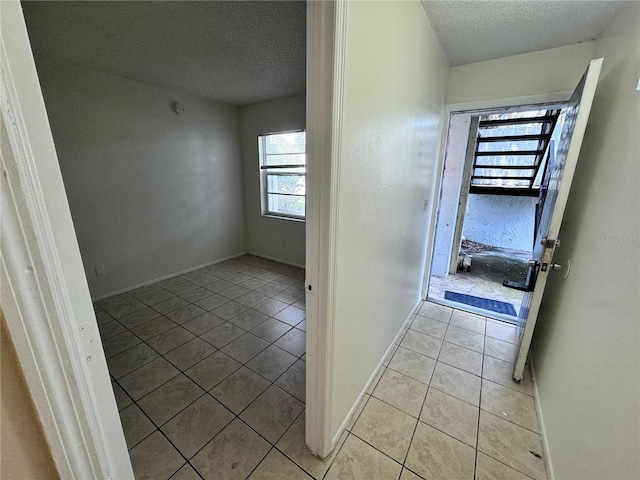 interior space with light tile patterned floors and a textured ceiling