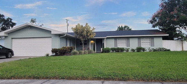 ranch-style house with a garage, driveway, fence, and a front yard