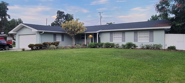 ranch-style house featuring an attached garage, fence, and a front lawn