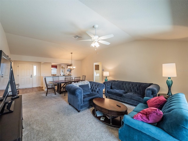 carpeted living room featuring lofted ceiling and ceiling fan with notable chandelier