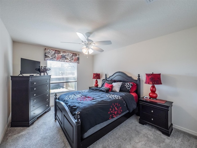 bedroom with ceiling fan, light colored carpet, and a textured ceiling