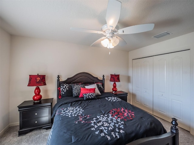 carpeted bedroom featuring ceiling fan and a closet