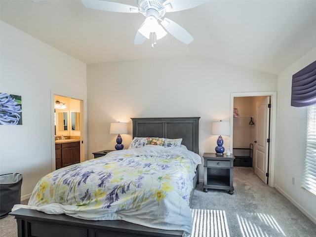 bedroom featuring lofted ceiling, sink, ceiling fan, light carpet, and ensuite bath